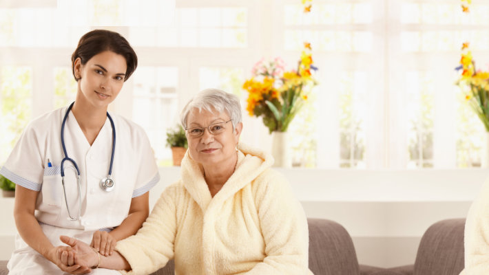 caregiver monitoring the vital signs of old woman